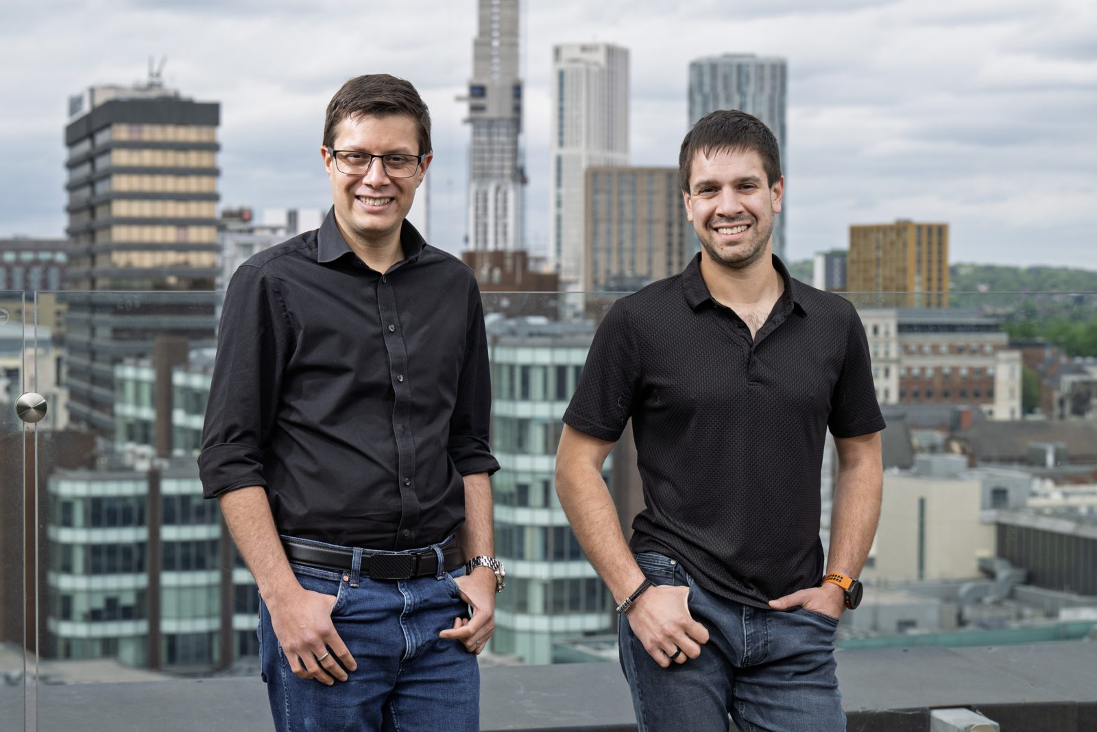 James Ridgway and Paul Ridgway, left to right, founders of The Curve, on a rooftop with a city skyline behind them